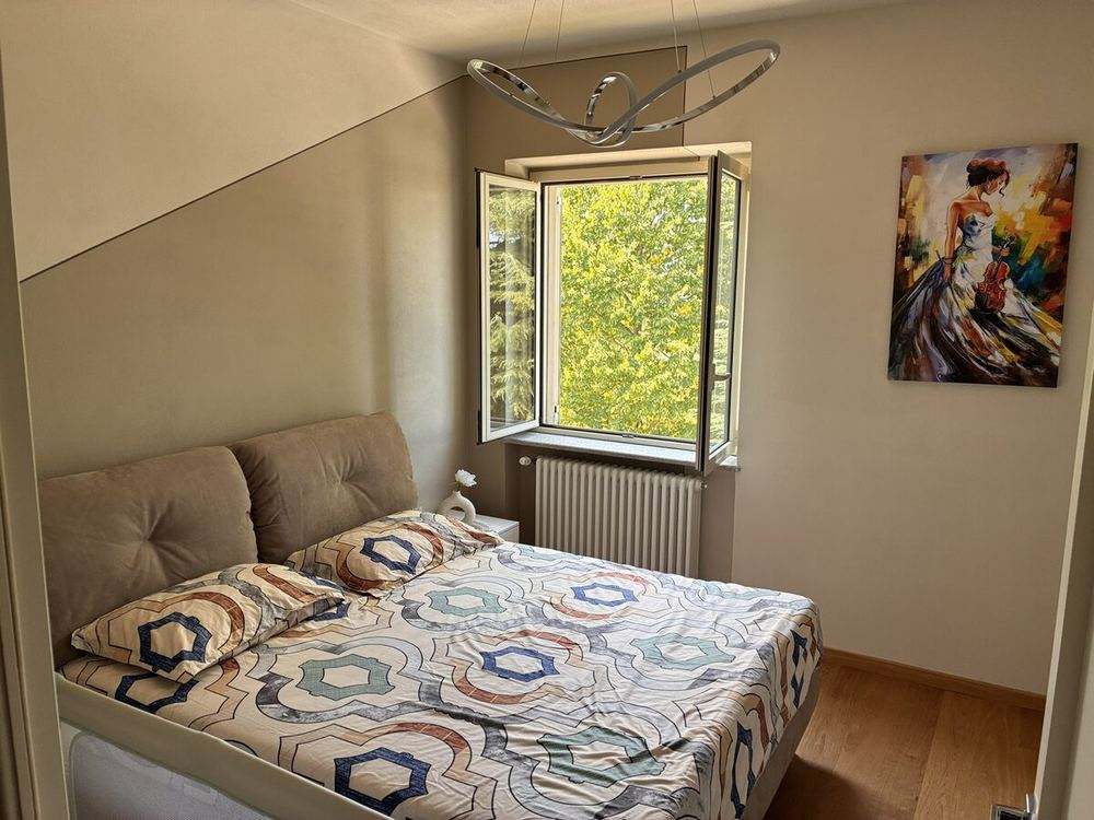 Bedroom prepared for guest arrival, natural light, bed made